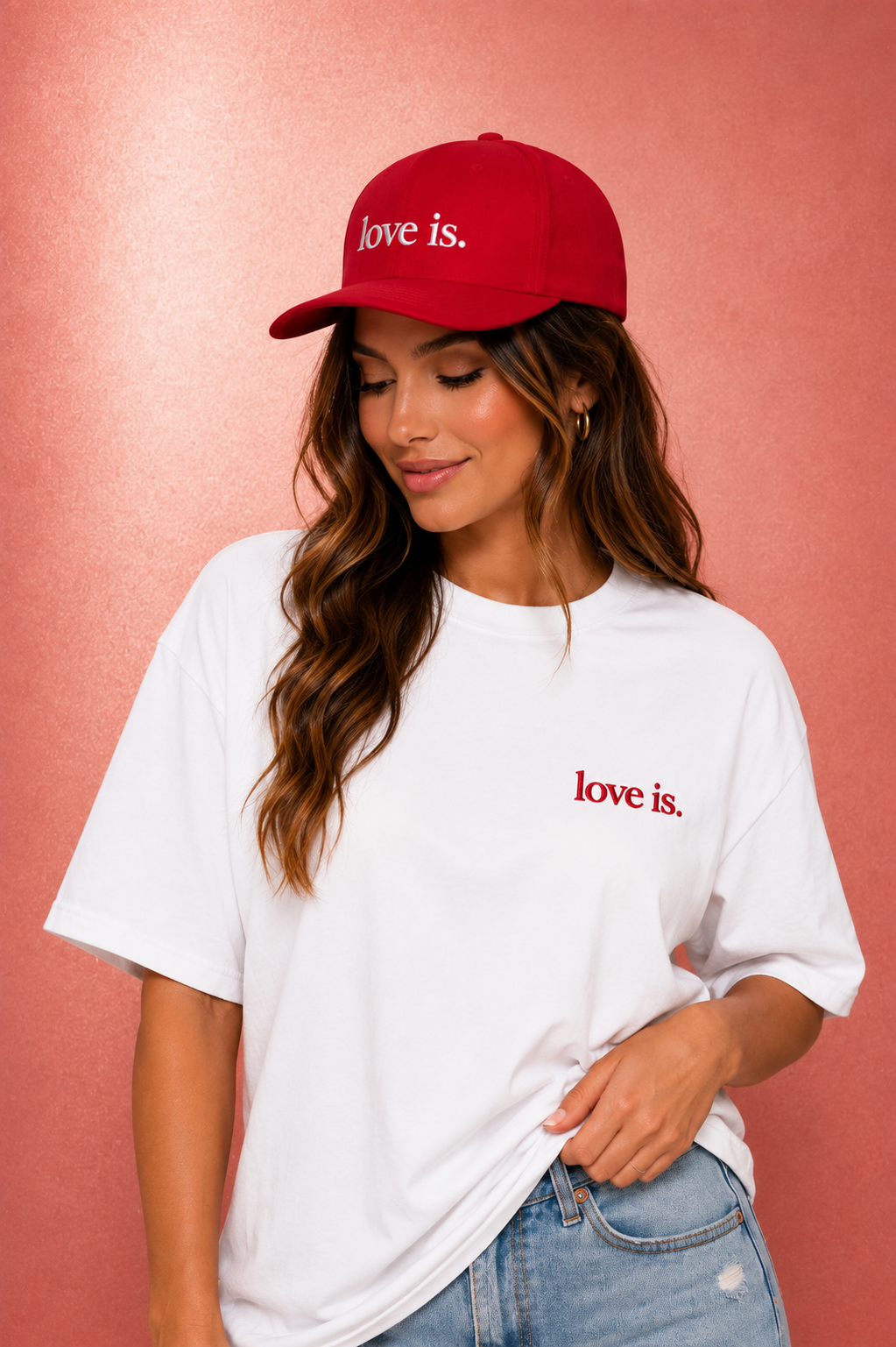 Woman wearing a red love is. snapback hat paired with a white oversized shirt. Minimalist Christian streetwear fashion.