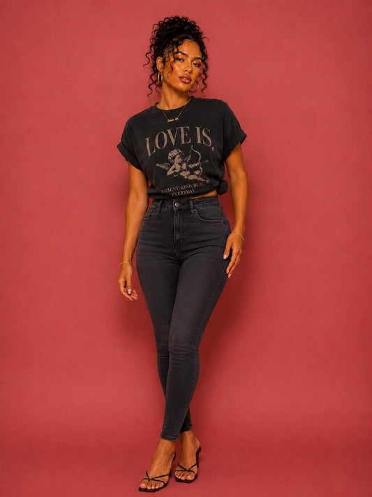 Female model wearing a vintage oversized Cupid graphic tee featuring the "Patient. Kind. Real. Everyday." love is. design